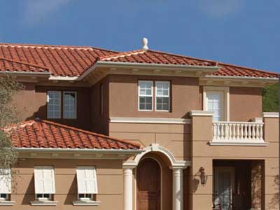 Front view of a mid-class, two-story light brown home with orange Boral clay tiles on its roof