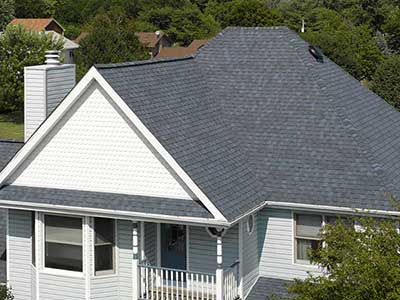 Front view of a mid-class, two-story white home with gray CertainTeed asphalt shingles on its roof