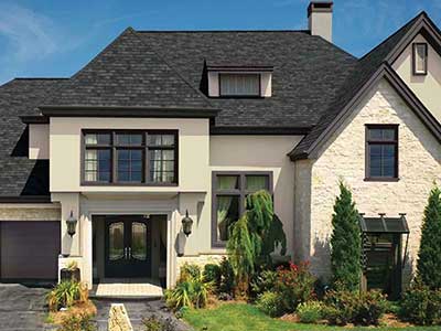 Front view of a mid-class, two-story beige home with black GAF asphalt shingles on its roof